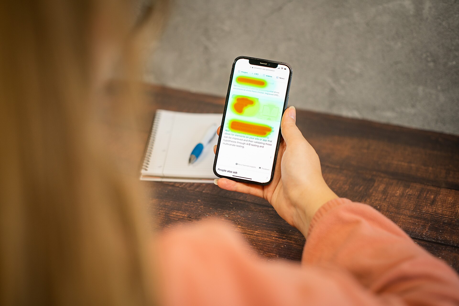 Pessoa segurando um celular que exibe o mapa de calor de uma página de site